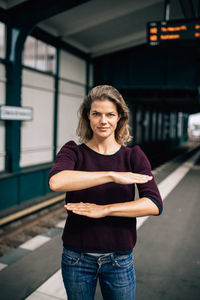 Portrait of woman standing at railroad station