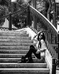 Full length of young woman sitting on steps