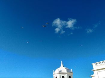 Low angle view of airplane flying against blue sky