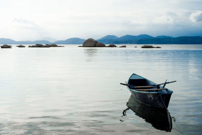 Boat moored on sea against sky