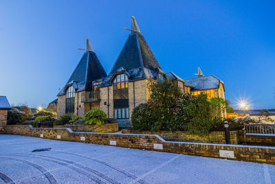 Buildings in city against clear blue sky