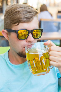 Close-up portrait of a man drinking glass