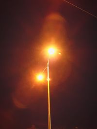 Low angle view of illuminated street light against sky