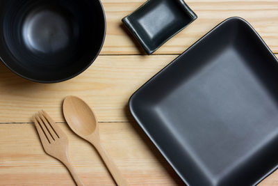 Black collection container on a wooden table