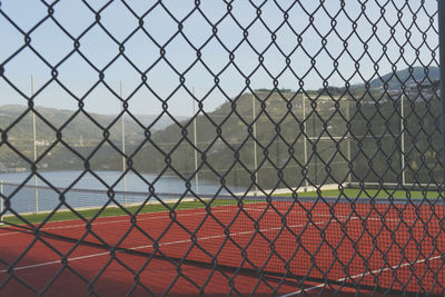 Close-up of field seen through chainlink fence