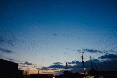 Low angle view of silhouette electricity pylon against sky at sunset