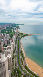 High angle view of buildings by sea against sky