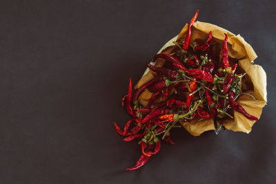 High angle view of red rose on table against black background