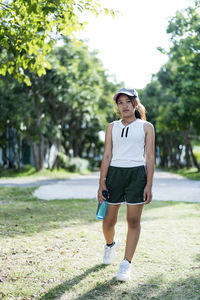 Woman walking in the park with bottle water in her hand health care concept.