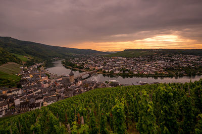 High angle view of river amidst buildings against sky during sunset