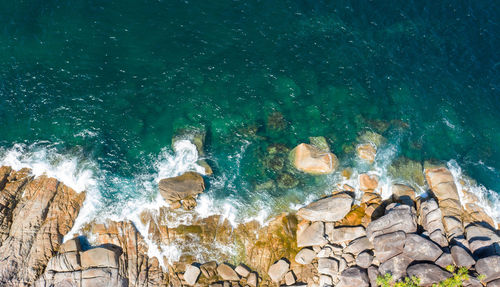 High angle view of waves splashing on rocks