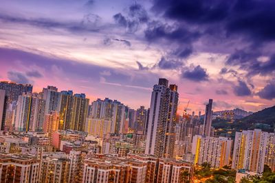 Modern buildings in city against sky during sunset