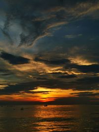 Scenic view of sea against dramatic sky during sunset