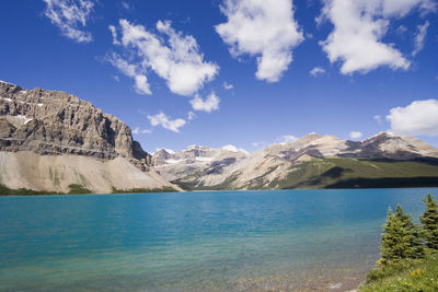 Scenic view of lake and mountains against blue sky