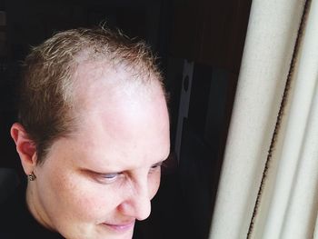 High angle view of woman with receding hairline looking through window