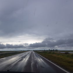 Highway against sky seen through car windshield