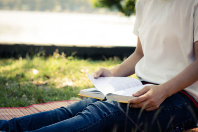 Midsection of woman with book