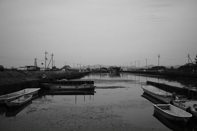 Boats moored at harbor against sky