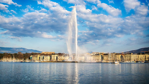 Fountain in lake against sky