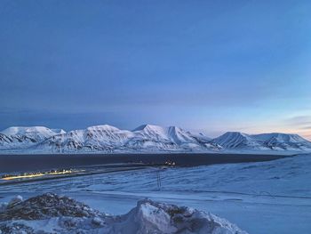 Scenic view of snowcapped mountains against blue sky