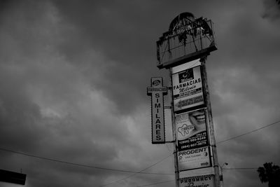 Low angle view of information sign against sky