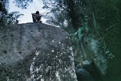 Low angle view of man standing on rock