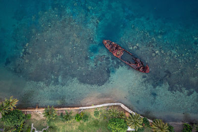 Top view of rusty wrecked boat in turquoise water near tropical shore. drone photo. sanma, vanuatu