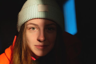 Cute girl in a hat, warm portrait. the sunset rays of the sun fall on her face, covering half of her