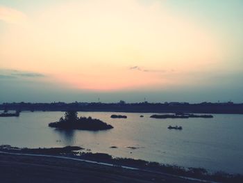 Boats in sea at sunset