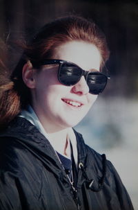 Close-up of smiling young woman wearing sunglasses