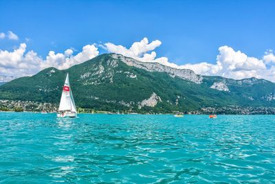 Sailboat sailing in sea against blue sky