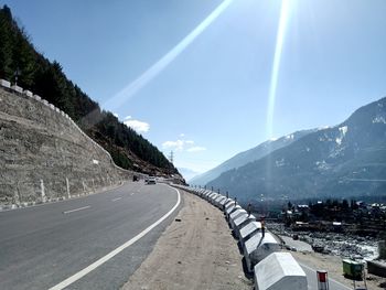 Road by mountain against sky