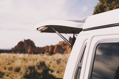 Cropped image of car against cloudy sky