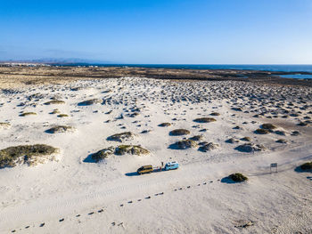 Scenic view of beach against clear blue sky