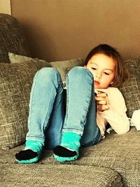 Young woman sitting on sofa at home