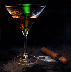 Close-up of wineglass on table against black background