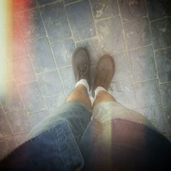 Low section of man standing on tiled floor