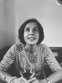 Smiling woman holding wineglass on table in restaurant