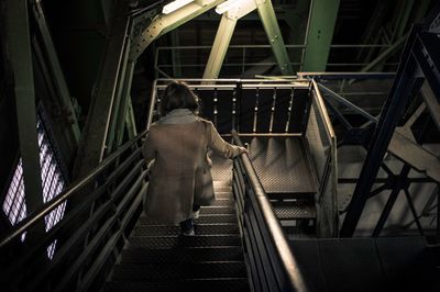 Rear view of woman walking on staircase