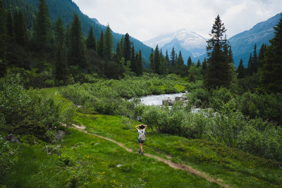 Rear view of woman hiking on mountain against sky