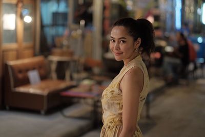 Portrait of smiling young woman standing at home