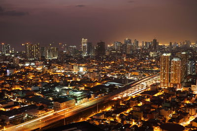 High angle view of illuminated buildings against sky at night