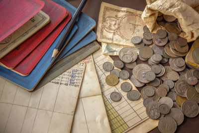 High angle view of passbook and coins on table
