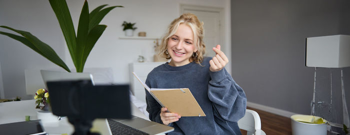 Portrait of young woman using digital tablet while sitting at home