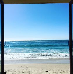 Scenic view of beach against clear blue sky