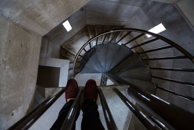 Low section of person standing on spiral staircase