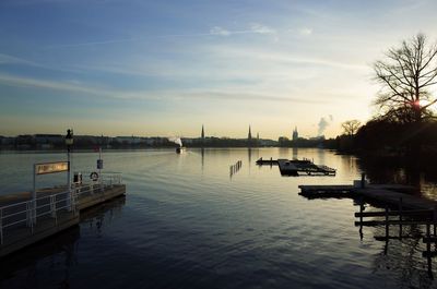 Boats in lake against sky during sunset