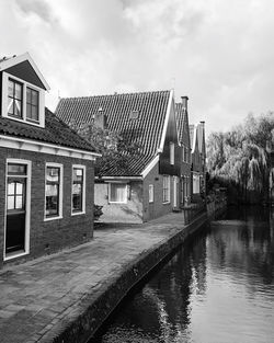 Building by river against sky