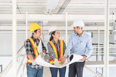 Engineers discussing over blueprint at site