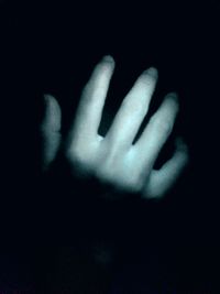 Cropped image of hand over black background